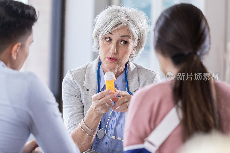 成熟的女医生与夫妇讨论药物