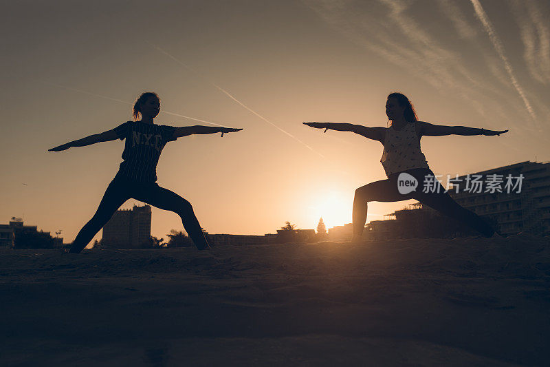 两个女人在海滩上练瑜伽