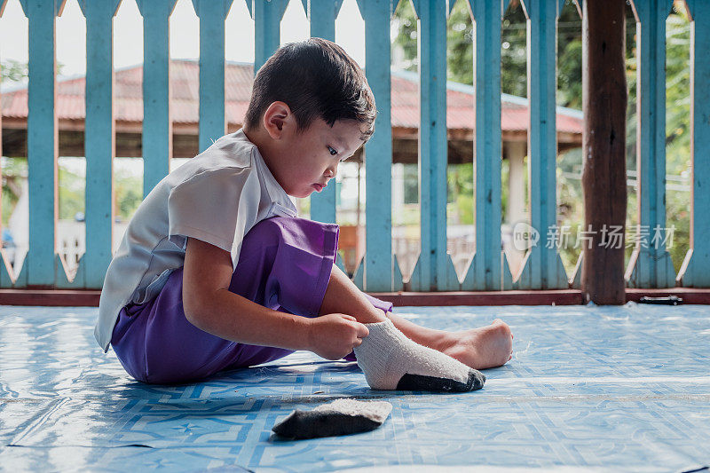 小学生自己动手穿袜子——孩子通过学习自己做事情来发展
