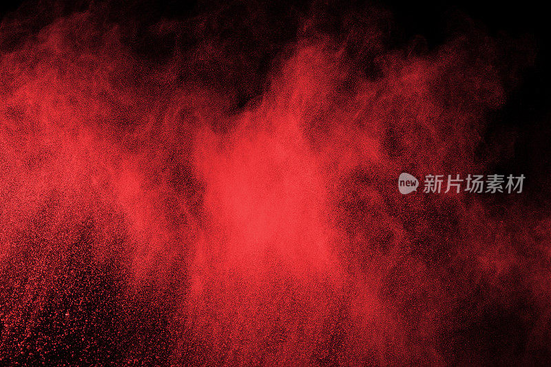 摘要红色粉末在黑色背景上爆炸。抽象的红色粉末溅在黑色背景上。冻结运动的红色粉末爆炸。