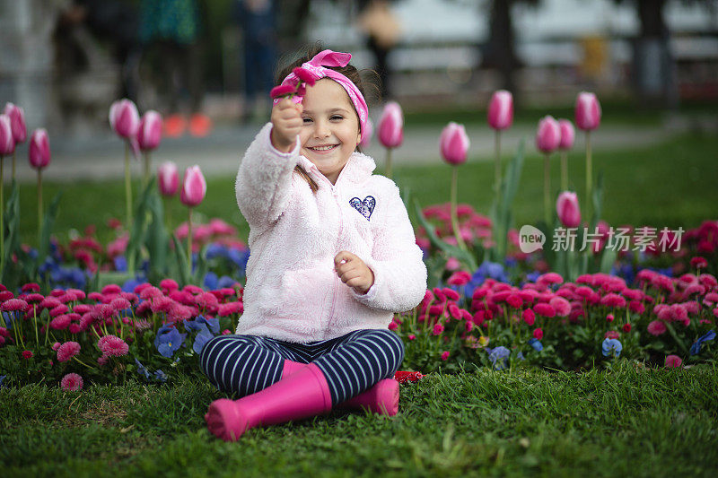 可爱快乐的小女孩在她当地的花园里玩耍