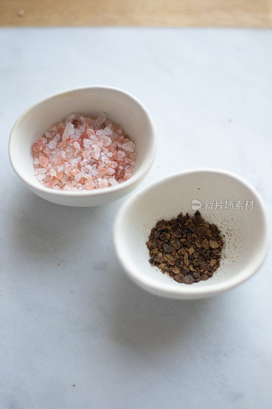 大理石背景上的喜马拉雅盐和胡椒