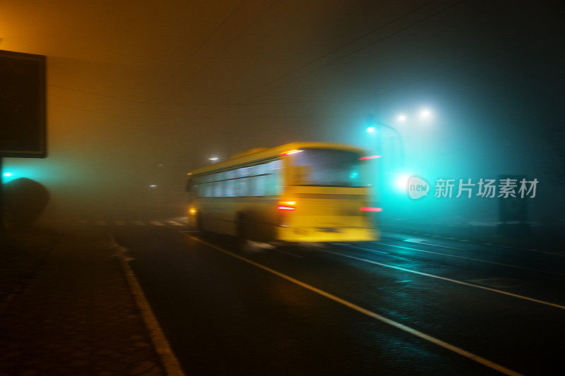 在一个雾蒙蒙的夜晚黄色的公共汽车