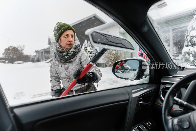 多民族家庭在暴风雪后清除汽车上的积雪