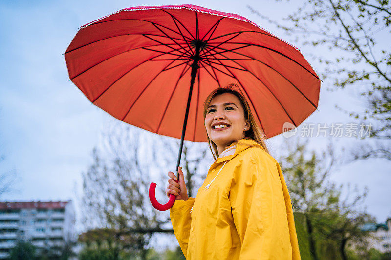 拿着红伞站在外面淋雨的女人