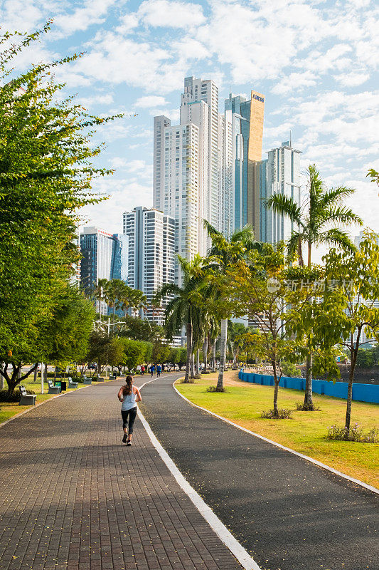 一名女子在公园里跑步，背景是巴拿马城