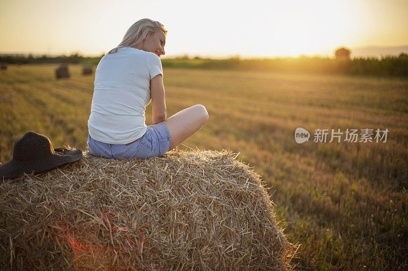 坐在乡下干草上的女人