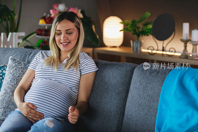 一位妇女感觉她的宝宝在肚子里踢，并看着超声波图像