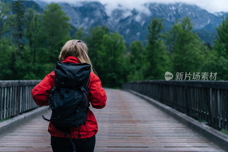 年轻女子徒步穿越森林中的一座桥