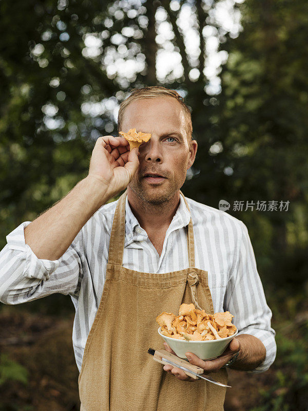 男男厨师在户外用鸡油菌和煎锅