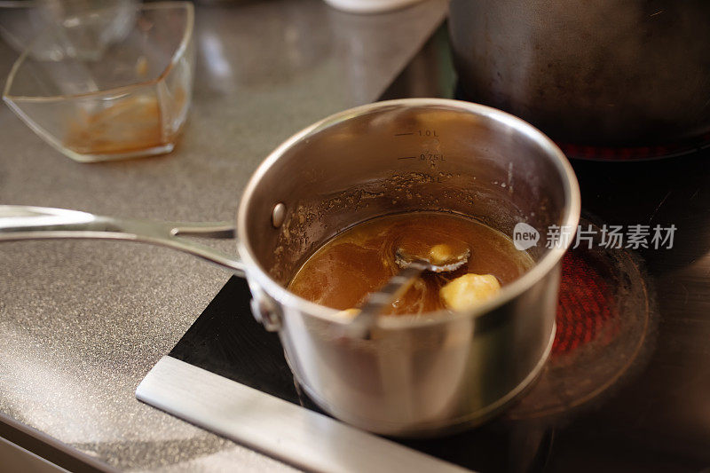 蜂蜜和黄油在厨房炉子上的平底锅里融化