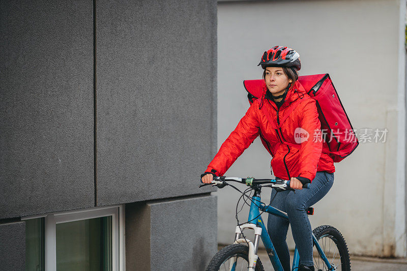 女性快递员在城市骑自行车