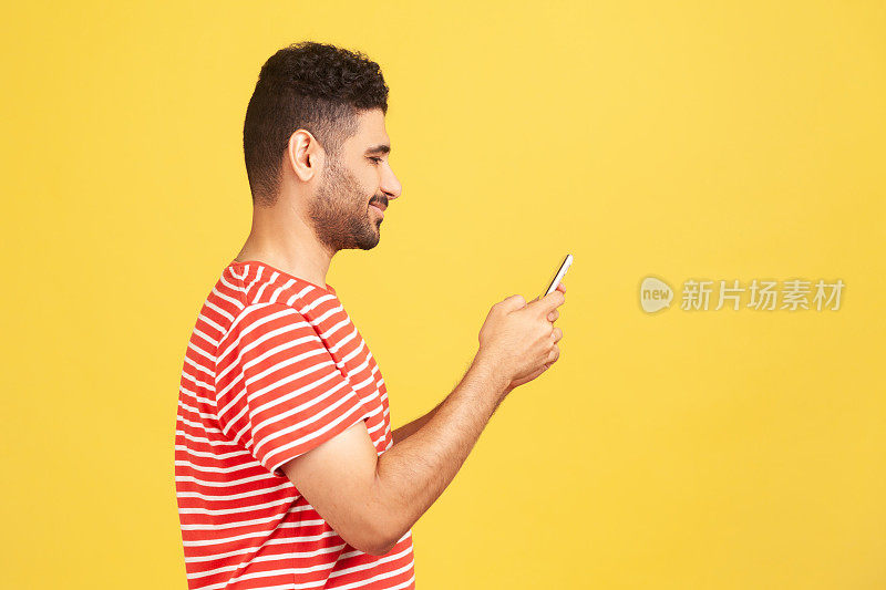 头像快乐的大胡子男人穿着红色条纹t恤在智能手机上发短信，在社交网络上进行在线对话