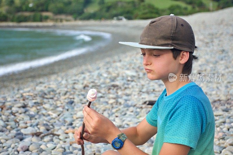 男孩在海边吃煮棉花糖