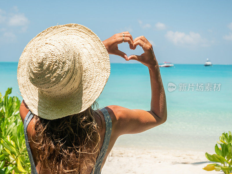 年轻女子日光浴在热带海滩热爱假期