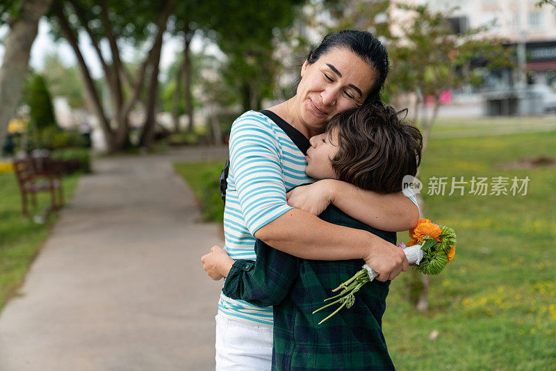 儿子为庆祝母亲节向母亲献花的照片