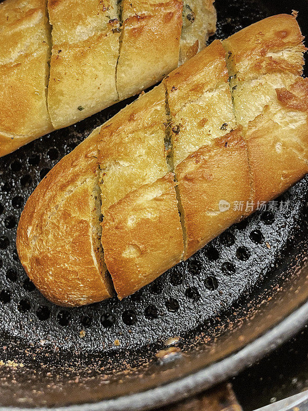 金色的特写图像，大蒜面包烤熟在空气炸锅，更健康的替代煎锅烹饪，提升的观点