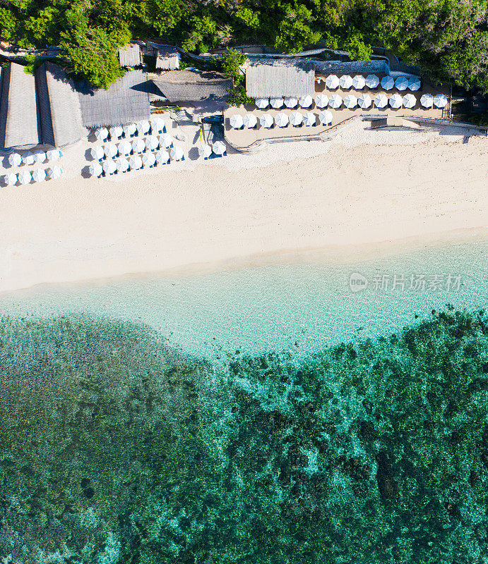 海滩伞和蓝色的海洋。从上面看海滩景色