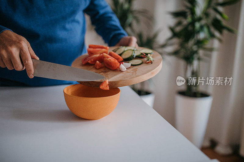 一个男人的手用菜刀切蔬菜