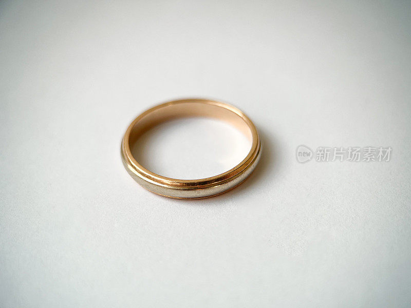金色结婚戒指，白色背景。红白相间的金戒指