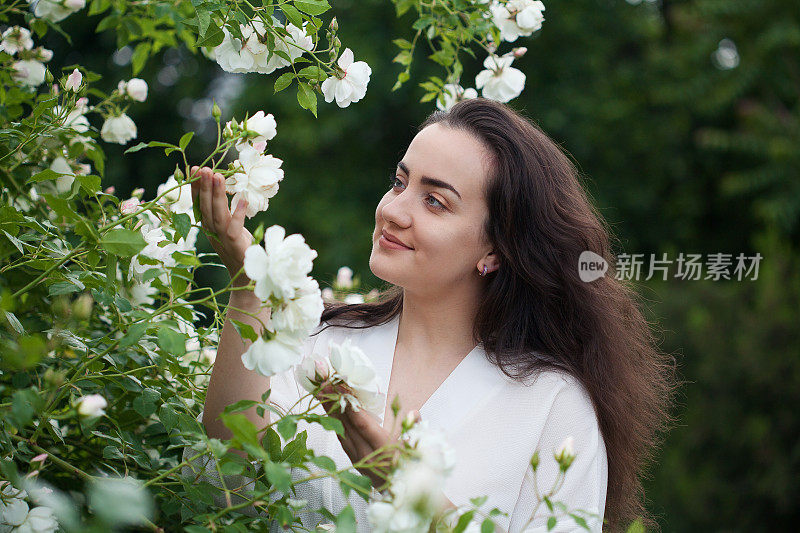 快乐的年轻女子在美丽的花园里