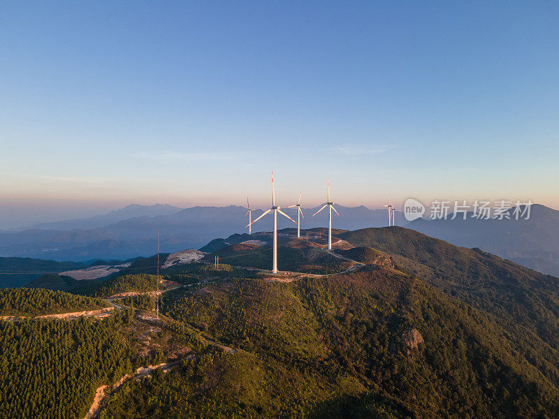 清晨阳光下山上风力发电的航拍照片