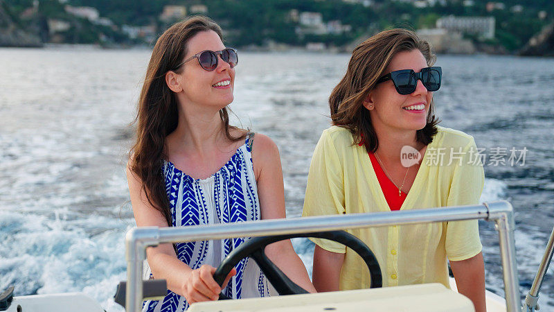 女性朋友在梦想的假期中享受快艇之旅。带着自然的微笑看风景