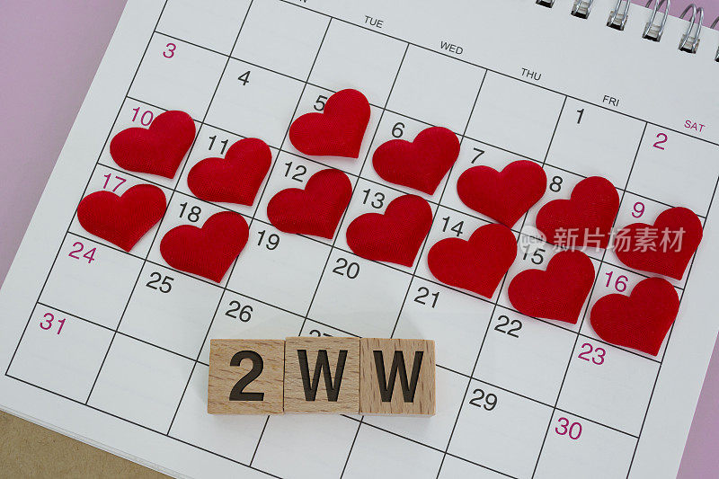 2WW字木版与红心形状日历。两周等待的概念