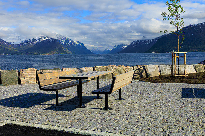 野餐的长凳和桌子，可以看到横跨Storfjorden和Hjørundfjorden的山脉