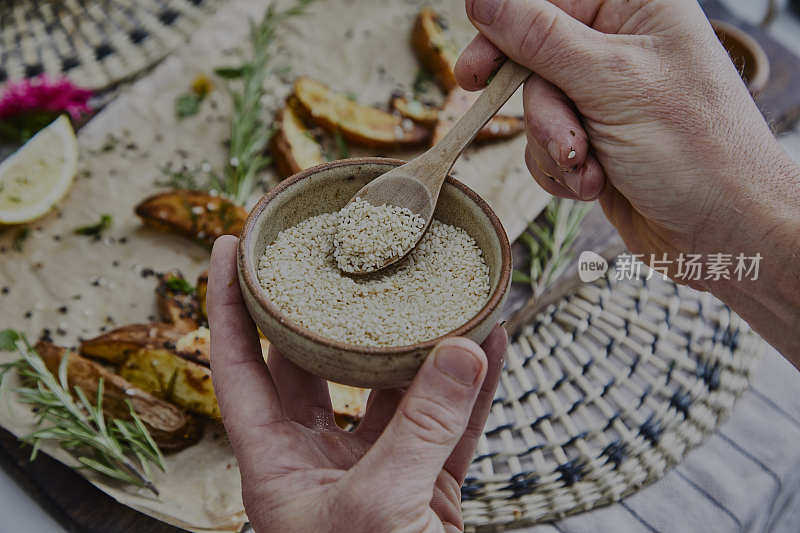 一名男子在烤土豆上加芝麻