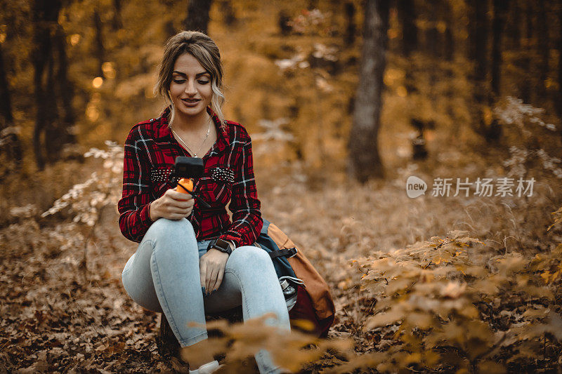 女人带着动作相机探索秋天的森林