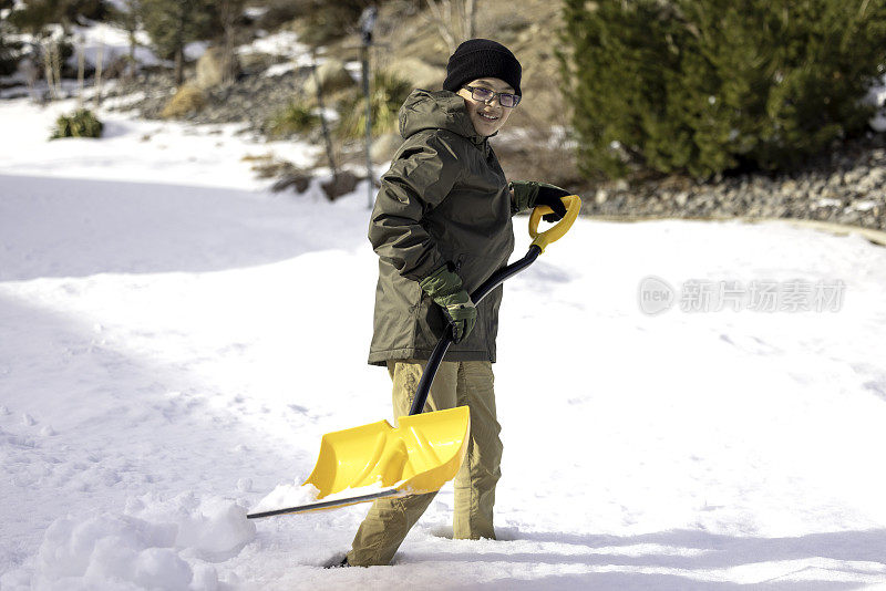 男孩在家里铲雪