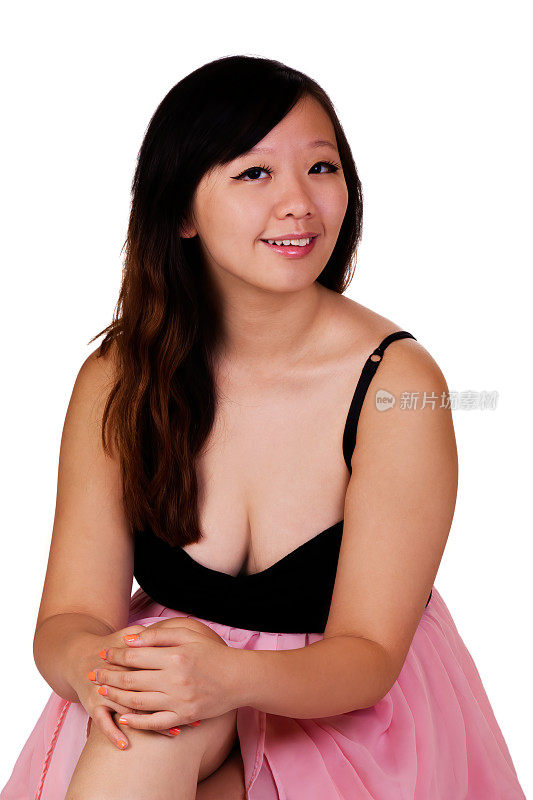 穿粉红和黑色连衣裙的华裔美国妇女坐着