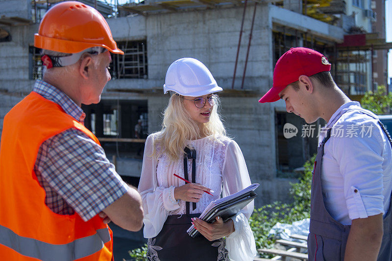 建筑工人正在向工程师询问设计图