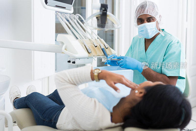 专注的牙医倾听女病人牙痛的抱怨