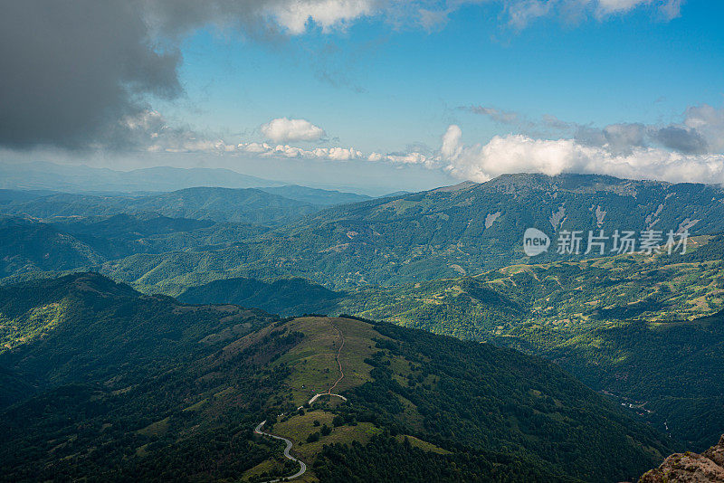 在一个阳光明媚的夏日里，有美丽的山峦和岩石景观。