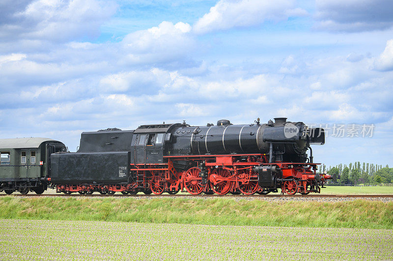 蒸汽火车带着火车头的烟雾行驶在乡间