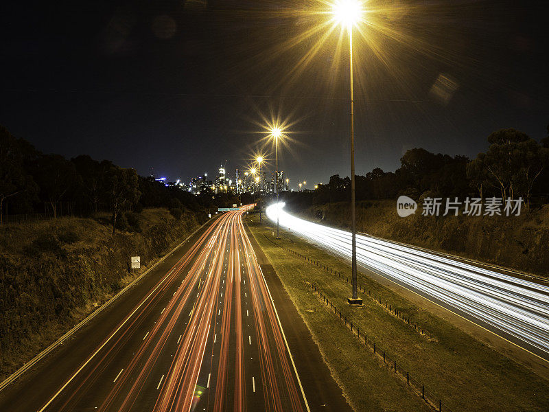 高速公路和城市天际线上的灯光痕迹