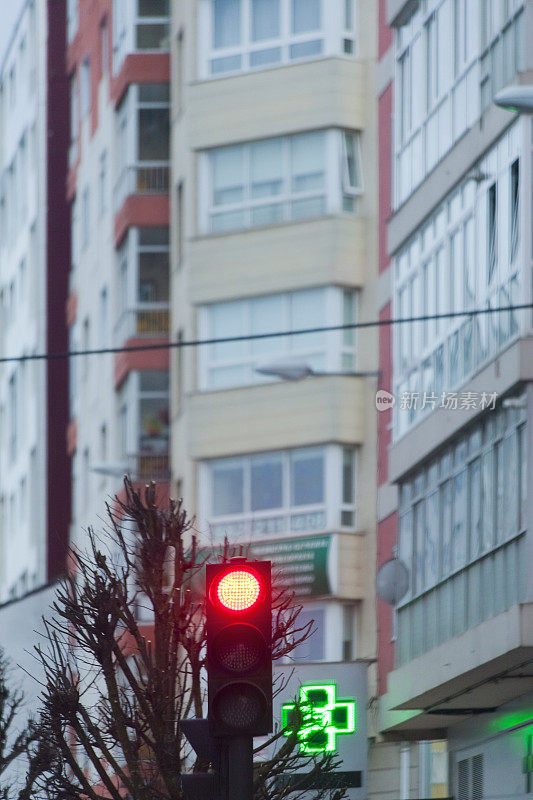 红绿灯，街上的药房标志，公寓楼，绿十字。