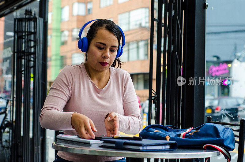 在咖啡店拿着平板电脑学习的女人