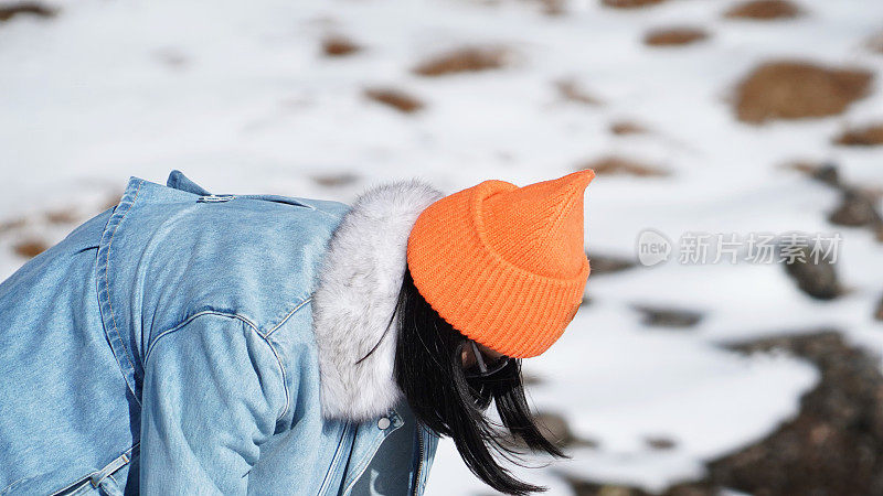 一个女人在寒冷的天气里穿行于白雪覆盖的山林之中