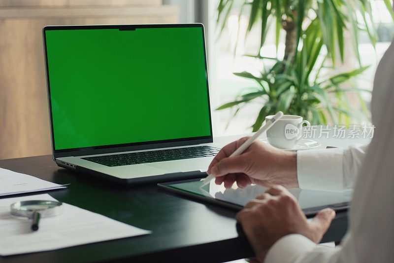 商人在办公室使用带有色度键绿屏的笔记本电脑
