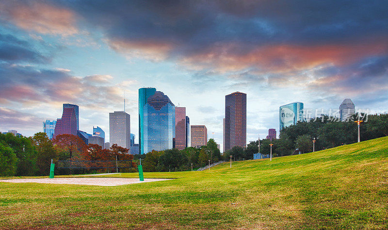 休斯顿天际线在阳光明媚的日子里，从美国得克萨斯州的公园草地
