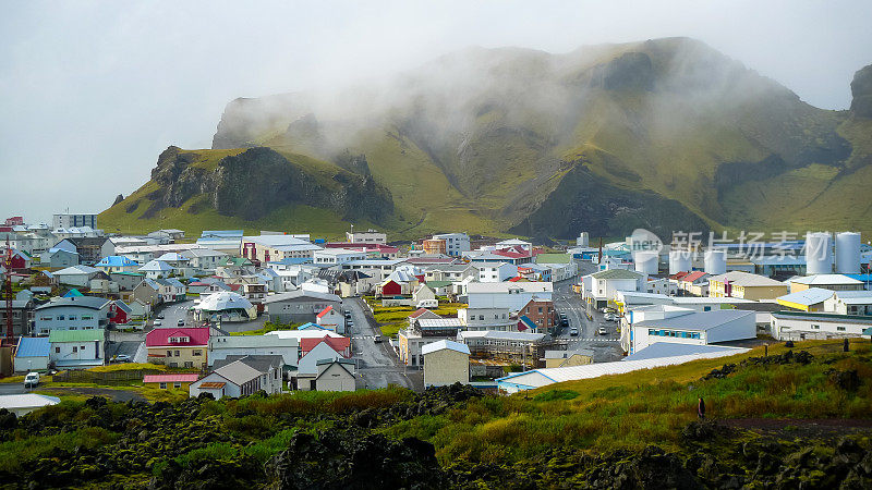 位于冰岛海岸外的宁静小镇Vestmannaeyjabær生活在两座火山的阴影下