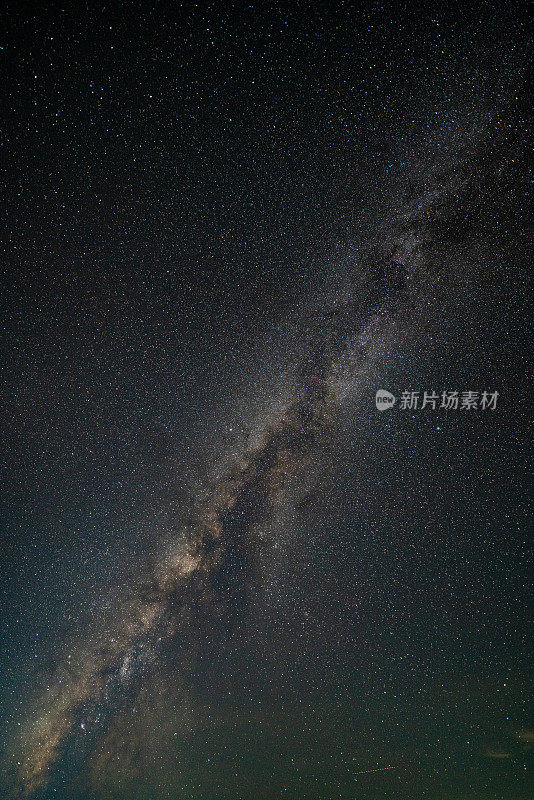 银河和粉红色的光在山上。晚上多彩的景观。