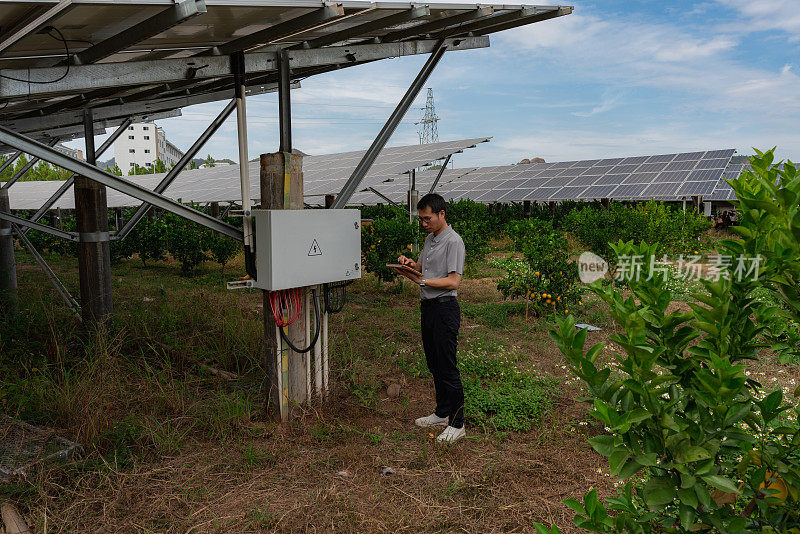 男工程师正在检查太阳能电池板的光伏合流箱