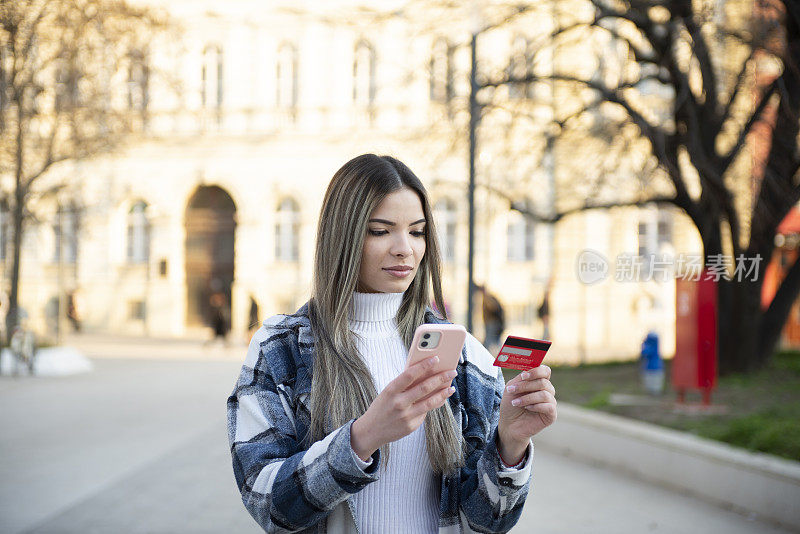 美丽的年轻女子度假时在城里购物