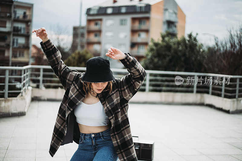 年轻的女孩正在屋顶上跳舞