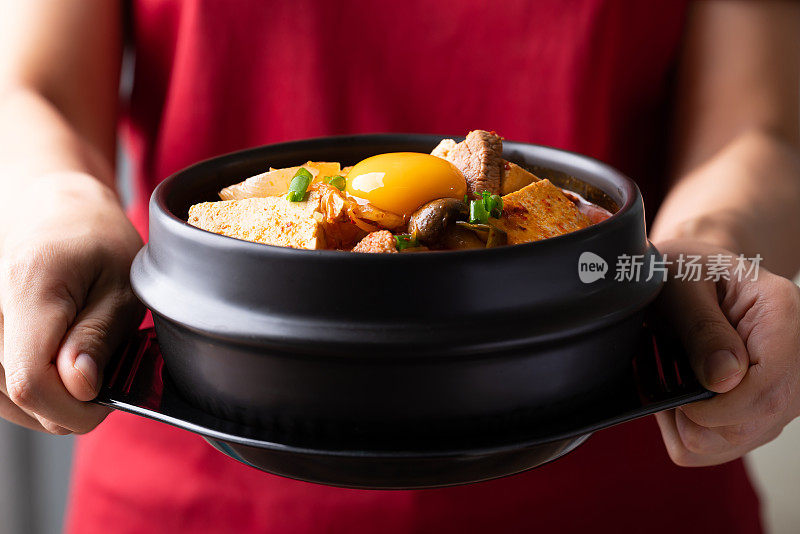 泡菜汤，豆腐，猪肉和鲜蛋黄在韩国石锅手拿