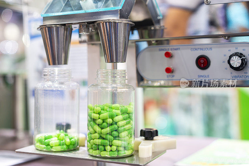 药用胶囊自动灌装计数机在生产过程中，将透明塑料瓶封闭在喷嘴分配器组件下